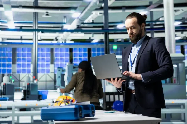 engineer-consultant-formal-attire-evaluates-factory-workflow